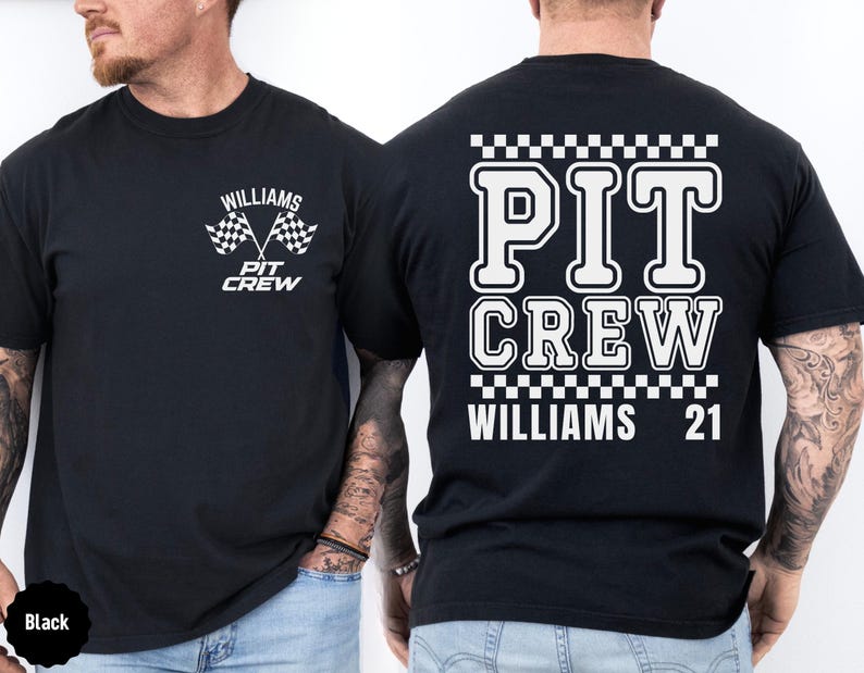 Op de afbeelding: Zwart T-shirt met witte tekst en geruit ontwerp. De tekst luidt "PIT CREW WILLIAMS 21" op de achterkant en "WILLIAMS PIT CREW" op de voorkant met een geruite vlaggrafiek.