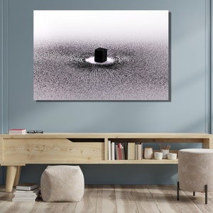 May include: A black and white abstract art print depicting a cube in the center of a swirling pattern of lines. The print is framed and hanging on a light blue wall above a wooden shelf.