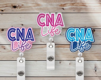 May include: Three glitter badge reels with the text "CNA Life" in different colors. The reels are pink, white, and blue. Each reel has a white retractable cord and a white clip.