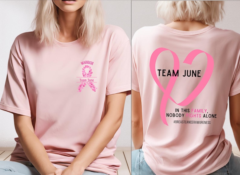 Peut inclure: Un t-shirt rose clair avec les mots "WARRIOR" et "Team June" imprim&eacute;s sur le devant, ainsi qu'un motif de ruban rose. Le dos du t-shirt pr&eacute;sente un grand ruban rose en forme de c&oelig;ur avec les mots "TEAM JUNE" et le message "IN THIS FAMILY, NOBODY FIGHTS ALONE".