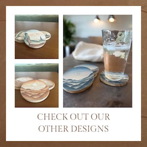 May include: Set of four round coasters with painted designs. Two coasters feature a mountain range with a crescent moon, and two coasters feature a desert landscape with a sun. The coasters are made of wood and have a natural finish.