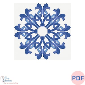 Puede incluir: Patrón de punto de cruz azul y blanco con un diseño de copo de nieve. El patrón es circular y tiene un diseño detallado.