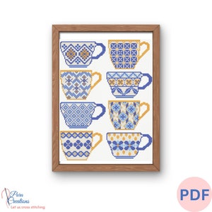 Puede incluir: Un patrón de punto de cruz con ocho tazas de té azules y amarillas con diseños geométricos. El patrón está enmarcado en un marco de madera marrón.