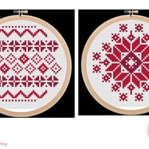 May include: Two circular wooden embroidery hoops containing white fabric with red cross-stitch patterns. The left hoop features horizontal rows of geometric shapes and wavy lines. The right hoop displays a large, symmetrical, star-like floral motif.