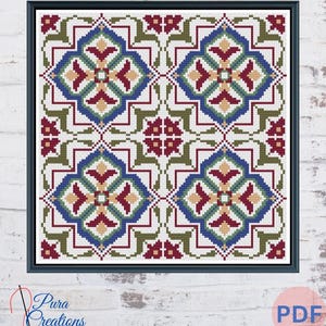 May include: A framed cross-stitch pattern featuring a repeating geometric design. The pattern includes blue, red, green, and tan elements on a white background. The frame is black, and the image is set against a white brick wall. The text "Pura Creations" is visible.