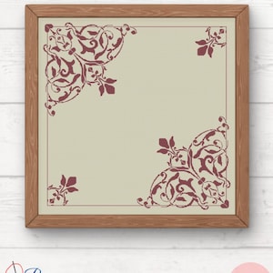 May include: A framed cross-stitch design with a beige background and a burgundy floral pattern in the corners.