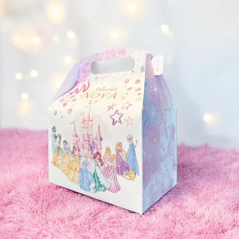 K&ouml;nnte beinhalten: Eine wei&szlig;e Papp-Geschenkbox mit Prinzessinnen-Motiv. Die Box zeigt ein Schloss, Sterne und eine Reihe von Disney-Prinzessinnen. Der Text auf der Box lautet "Princesa NOVA 5/7".