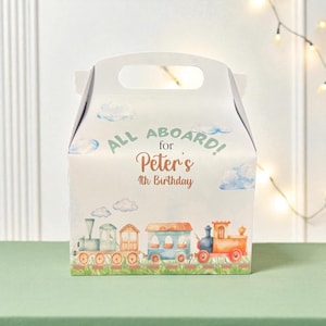 May include: A white party favor box with a handle, decorated with a watercolor train scene and clouds. Text reads "ALL ABOARD! for Peter's 4th Birthday". The train is composed of orange, blue, and green cars.