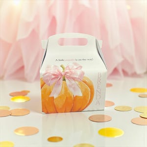 Può includere: Una scatola regalo bianca con manico, con un'illustrazione di zucca arancione e un fiocco rosa. Il testo "A little pumpkin is on the way!" è stampato sulla scatola, insieme al nome "Brenda" in rosa. Coriandoli dorati e ramati sparsi.