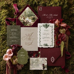 May include: A wedding stationery suite featuring burgundy velvet envelopes, cream and olive green cards with ornate typography, and floral accents. The set includes a Save the Date, RSVP card, and wedding details, all displayed with a landscape image insert.