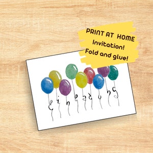 May include: A white invitation card with watercolor balloons in various colors, including blue, yellow, green, and purple. The word "birthday" is written in a whimsical font below the balloons. Text on the card reads "Print at Home Invitation! Fold and glue!"