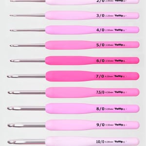 May include: A collection of nine crochet hooks with pink handles and silver metal tips. Each hook is labelled with a size, ranging from 2/0 (2.00mm) to 10/0 (6.00mm), and the brand name "Tulip". The handles are in various shades of pink.