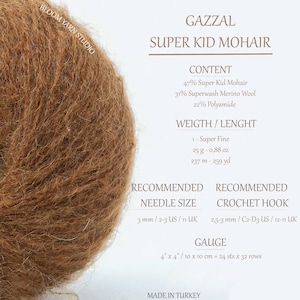 May include: A ball of brown Super Kid Mohair yarn by Gazzal. The yarn is 47% Super Kid Mohair, 31% Superwash Merino Wool, and 22% Polyamide. The recommended needle size is 3 mm/2-3 US/11 UK. The recommended crochet hook size is 2.5-3 mm/C2-D3 US/12-11 UK. The gauge is 24 stitches and 32 rows per 10 cm.