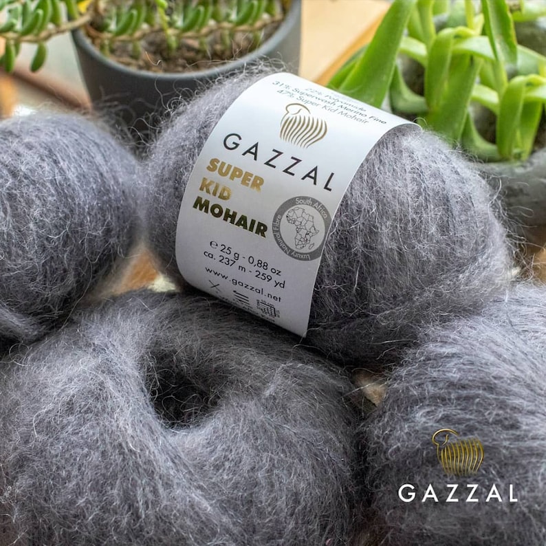 May include: Two skeins of gray Super Kid Mohair yarn by Gazzal. The label reads "Super Kid Mohair" and "South African Finest Angora Mohair".