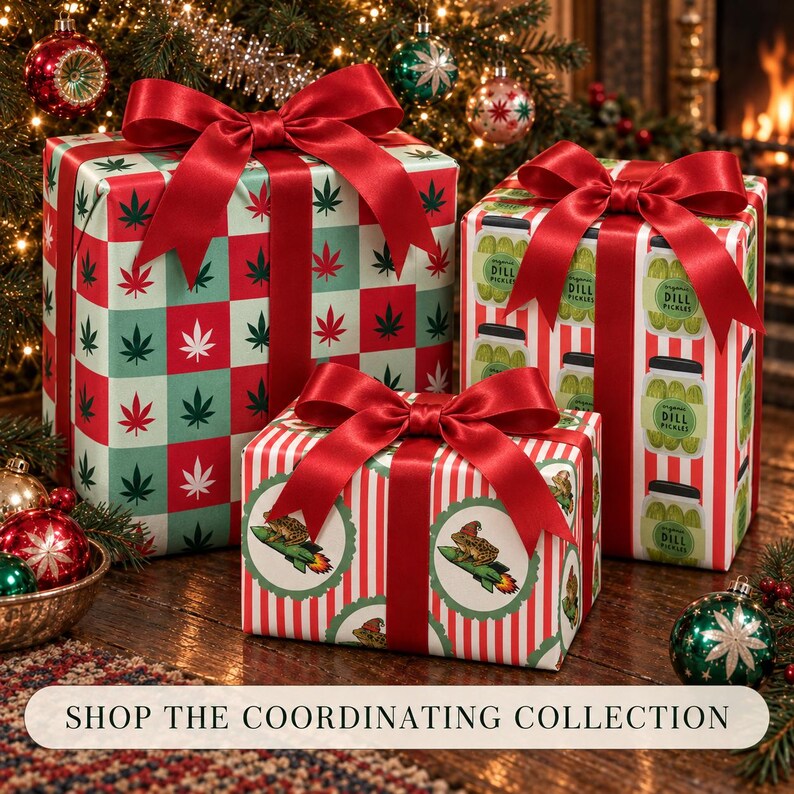 May include: Three rectangular gift boxes wrapped in patterned paper and tied with red satin ribbons. One box features a red and green cannabis leaf checkerboard pattern, another shows jars of dill pickles, and the third displays frogs on rockets.