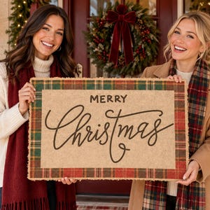 May include: A rectangular coir doormat featuring a natural tan center with the text Merry Christmas in black script lettering, framed by a red, green, and gold plaid border with a frayed edge, designed for seasonal holiday home entryway decor.