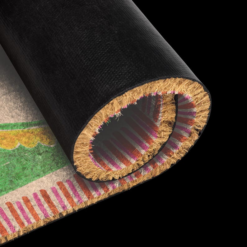 May include: A partially rolled doormat featuring a natural tan coir surface with a green and yellow scalloped pattern and a border of alternating pink and orange vertical stripes. The underside of the mat is a solid black, smooth material.