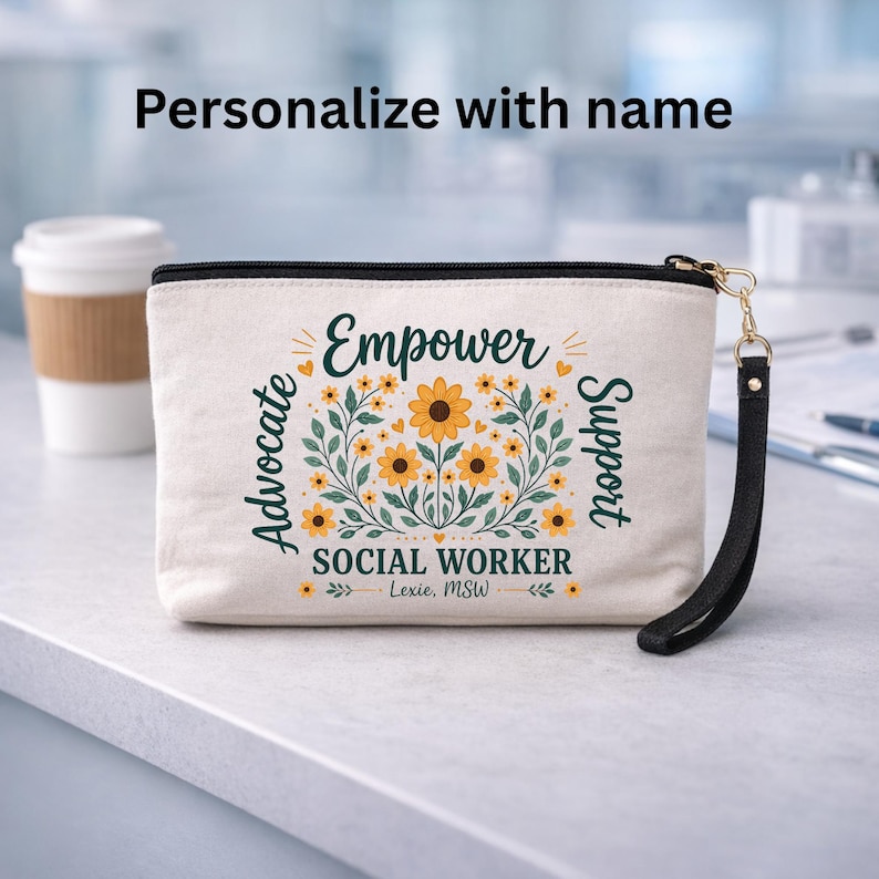 May include: Cream-colored zippered pouch with the words "Empower Advocate Support" and "Social Worker" printed on it. The design includes yellow sunflowers and green leaves. A black wrist strap is attached to the zipper.