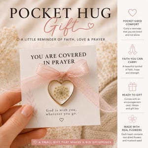 Może przedstawiać: Karta podarunkowa Pocket Hug z wisiorkiem w kształcie serca zawierającym suszone kwiaty i napisem "You are covered in prayer". Karta jest zawiązana r&oacute;żową wstążką i zawiera napis "God is with you, wherever you go."