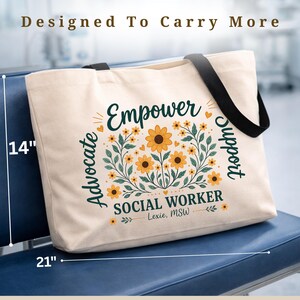 May include: Cream-colored tote bag with black straps, measuring 21 inches wide and 14 inches high. The bag features the words "Empower," "Advocate," and "Support," along with "SOCIAL WORKER" and a floral design.