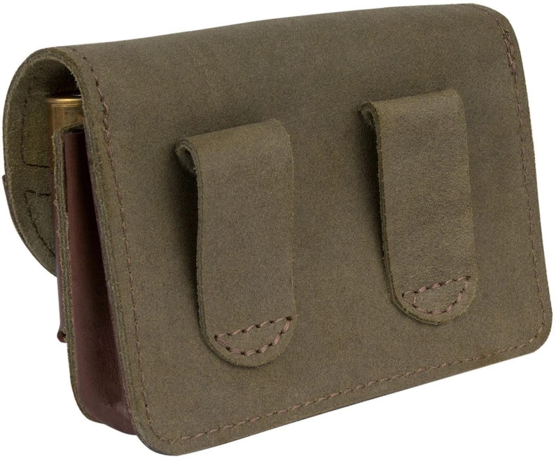 Puede incluir: Una bolsa de cuero verde con dos solapas y una solapa de cuero marr&oacute;n en la parte delantera. La bolsa tiene un dise&ntilde;o cosido y est&aacute; hecha de un material duradero.