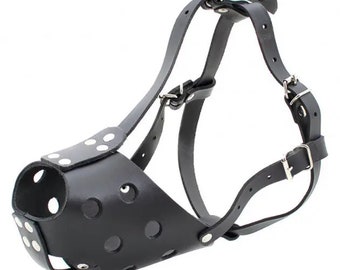 May include: Black leather dog muzzle with adjustable straps and metal buckles. The muzzle has a perforated design for ventilation.