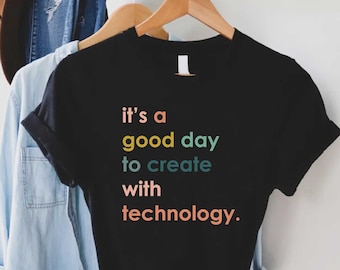 May include: Black t-shirt with the text "it's a good day to create with technology." in rainbow colors.