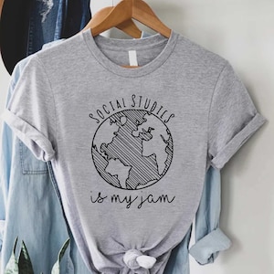 May include: A grey t-shirt with a black graphic of a globe and the text "Social Studies is my jam".