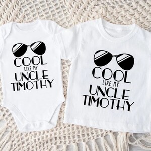 May include: Two white t-shirts with black text and sunglasses graphics. The text reads "Cool like my Uncle Timothy".