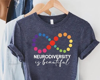 May include: A dark blue t-shirt with a rainbow infinity symbol and the text "Neurodiversity is beautiful".