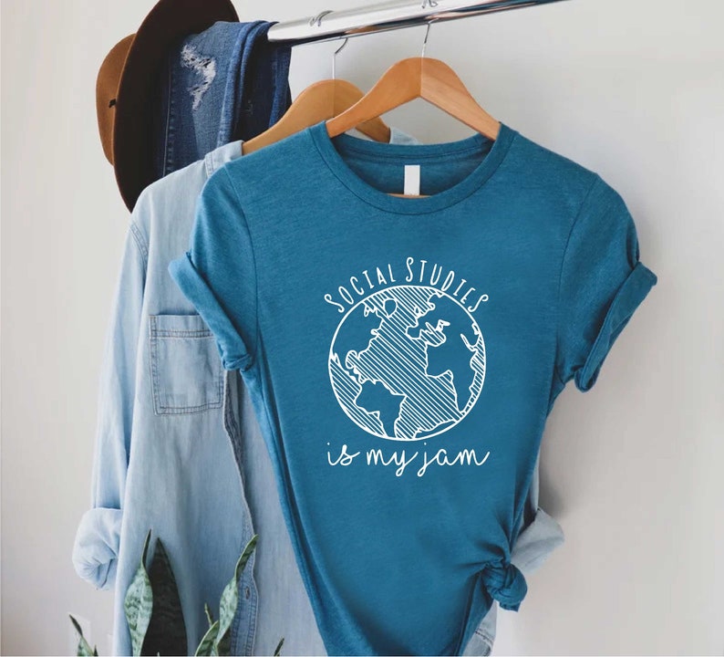 May include: A teal blue t-shirt with a white graphic of a globe and the text "Social Studies is my jam".