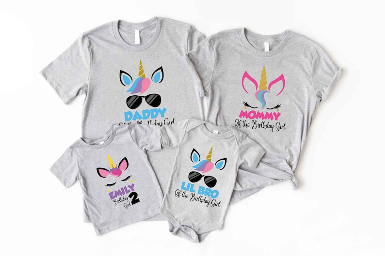 May include: Set of four grey t-shirts with unicorn designs and text. The shirts say "Daddy of the Birthday Girl", "Mommy of the Birthday Girl", "Lil Bro of the Birthday Girl", and "Emily 2 Birthday Girl".