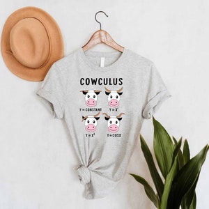 May include: A gray t-shirt with the text "COWCULUS" and a graphic of four cows with different mathematical equations above their heads. The equations are Y=CONSTANT, Y=X, Y=X^2, and Y=COSX.