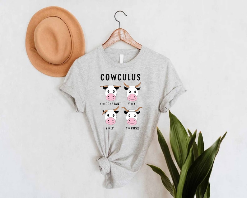 May include: A gray t-shirt with the text "COWCULUS" and a graphic of four cows with different mathematical equations above their heads. The equations are Y=CONSTANT, Y=X, Y=X^2, and Y=COSX.