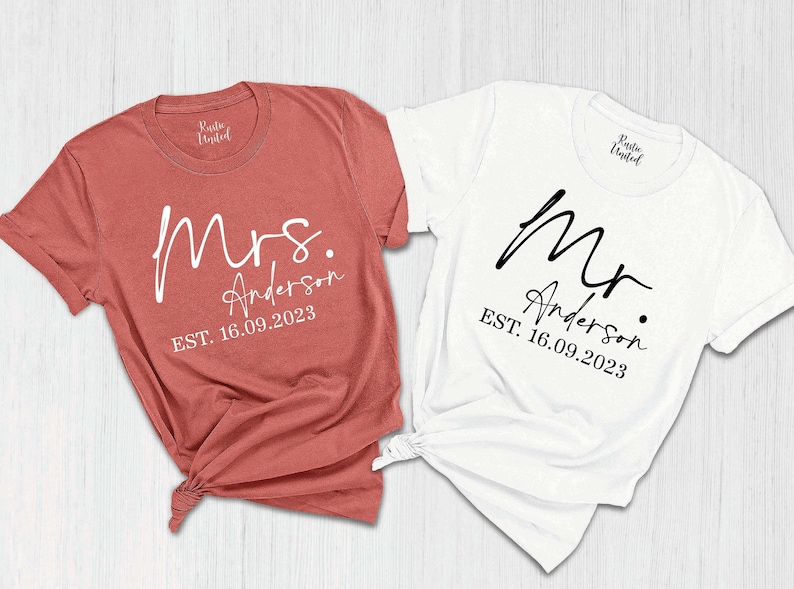 May include: Two t-shirts, one red and one white, with the text "Mrs. Anderson EST. 16.09.2023" and "Mr. Anderson EST. 16.09.2023" printed on them.