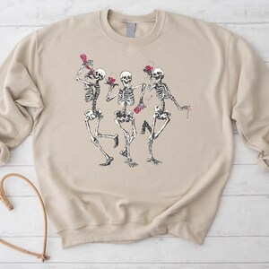 a sweater with a picture of two skeletons dancing