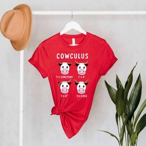 May include: Red t-shirt with a white graphic of cows and math equations. The text on the shirt reads "COWCULUS".