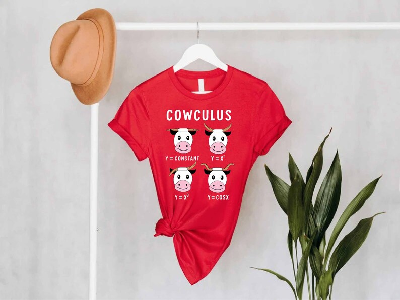 May include: Red t-shirt with a white graphic of cows and math equations. The text on the shirt reads "COWCULUS".