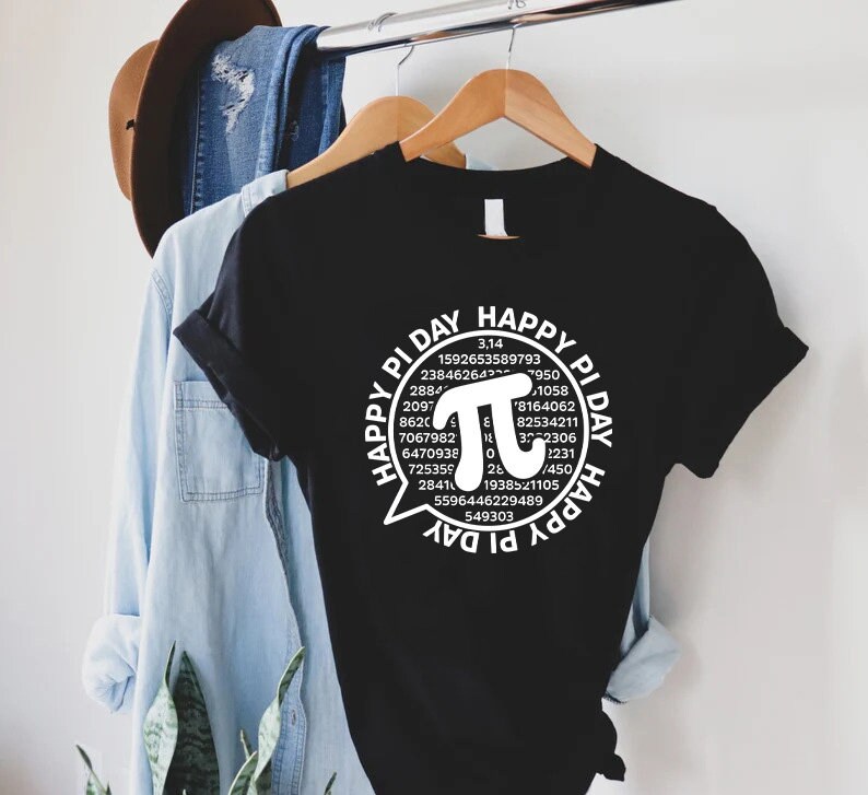 Puede incluir: Camiseta negra con un gr&aacute;fico blanco de un bocadillo de di&aacute;logo con el texto "Happy Pi Day" y un gran s&iacute;mbolo pi con los 30 primeros d&iacute;gitos de pi.