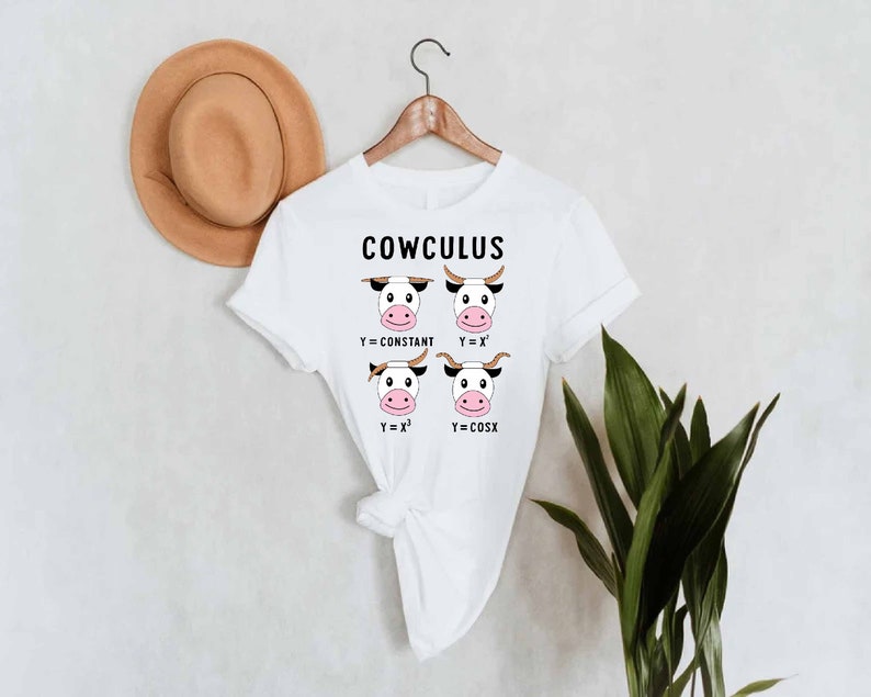 May include: White t-shirt with a graphic of cows representing different calculus equations. The text "COWCULUS" is printed above the cows.