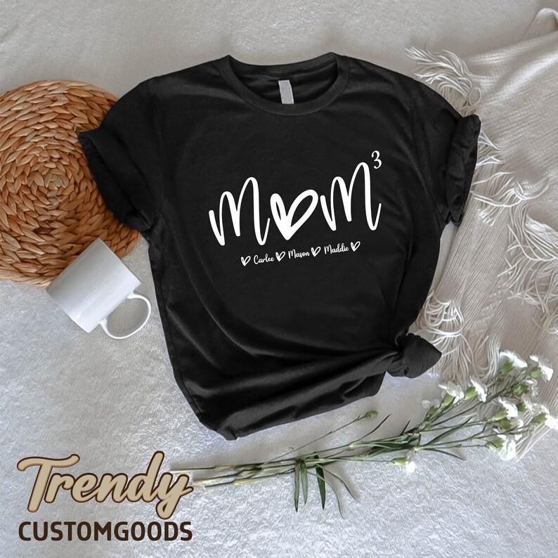 a black t - shirt with the word mom printed on it