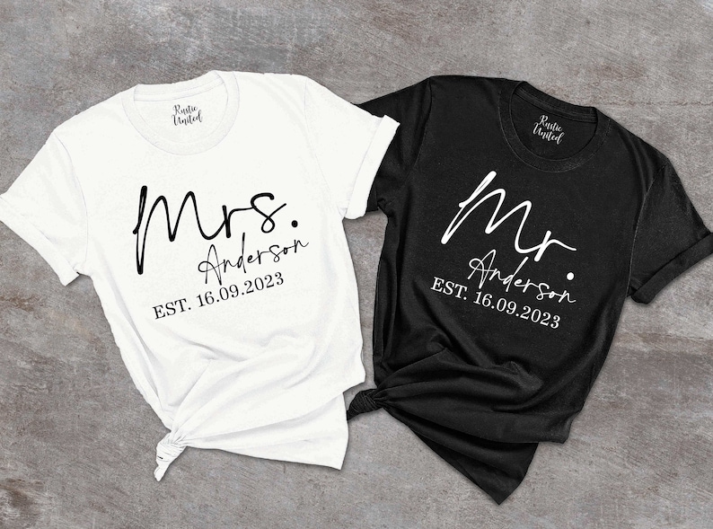 May include: Two white t-shirts with black text. One shirt says "Mrs. Anderson EST. 16.09.2023" and the other says "Mr. Anderson EST. 16.09.2023".