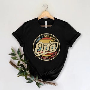 May include: Black t-shirt featuring a vintage-style graphic that reads "Like a Grandpa, Only Cooler" with the word "Opa" in a large, stylised font.