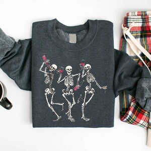 a couple of skeleton shirts sitting next to a cup of coffee