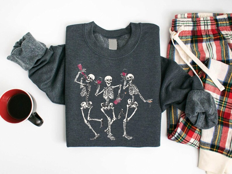 a couple of skeleton shirts sitting next to a cup of coffee