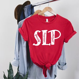 Puede incluir: Camiseta roja con texto blanco que dice "SLP" con las palabras "speech", "language" y "pathologist" escritas verticalmente dentro de las letras.