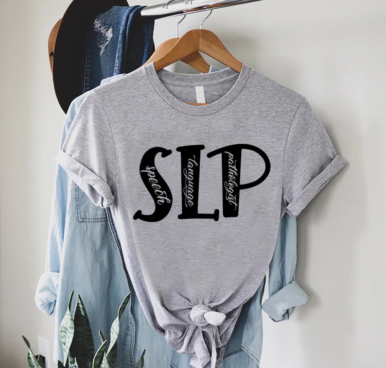 Puede incluir: Camiseta gris con texto negro que dice "SLP" con las palabras "speech", "language" y "pathologist" escritas verticalmente dentro de las letras.