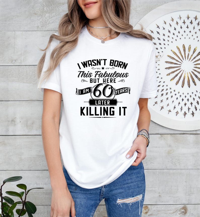 May include: White t-shirt with black text that reads "I wasn't born this fabulous but here I am 60 years later killing it".