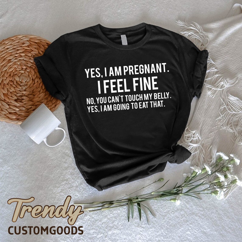Może przedstawiać: Czarny T-shirt z białym tekstem, kt&oacute;ry brzmi "YES, I AM PREGNANT. I FEEL FINE. NO, YOU CAN'T TOUCH MY BELLY. YES, I AM GOING TO EAT THAT."