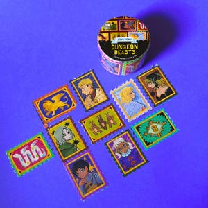 Puede incluir: Un rollo de cinta washi con un diseño colorido que presenta ilustraciones de criaturas míticas y personajes. La cinta está etiquetada como "Dungeon Beasts" y "Joylychi". La cinta está rodeada de pegatinas individuales con diseños similares.